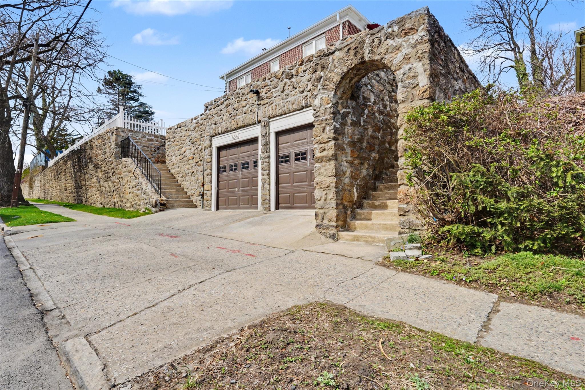 View of side of property with stone siding and driveway