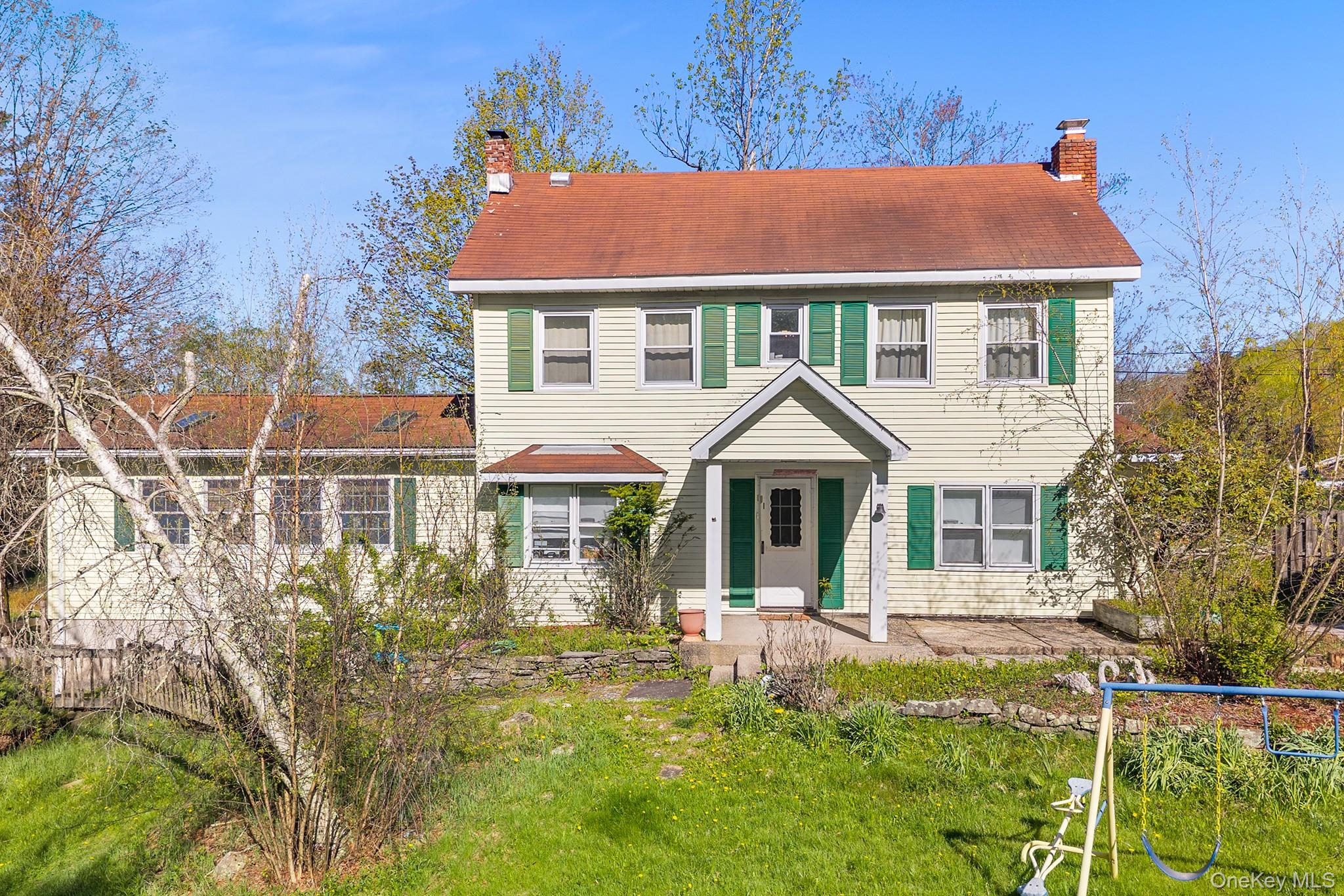 Two-story residence featuring siding exterior, an inviting covered front porch, and a red-toned roof
