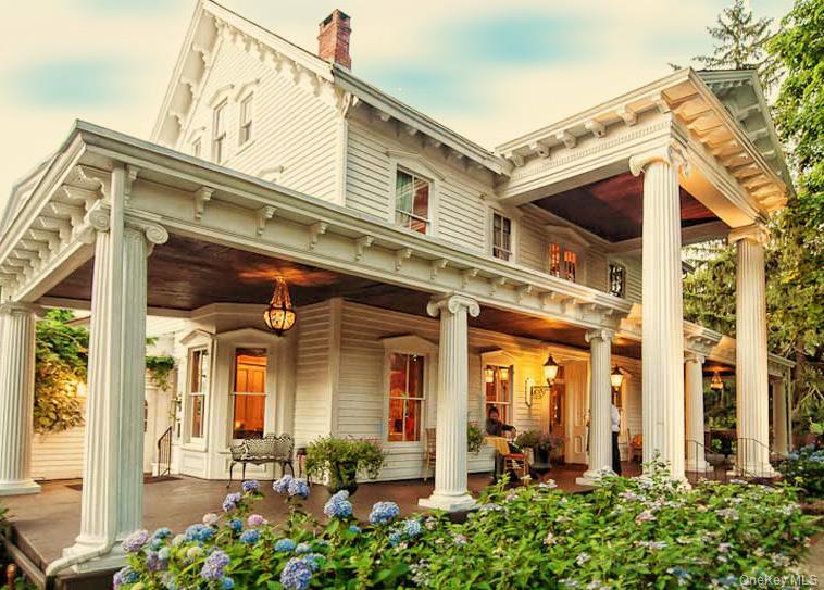 Victorian-style residence featuring a prominent full-width porch with fluted columns and detailed trim work