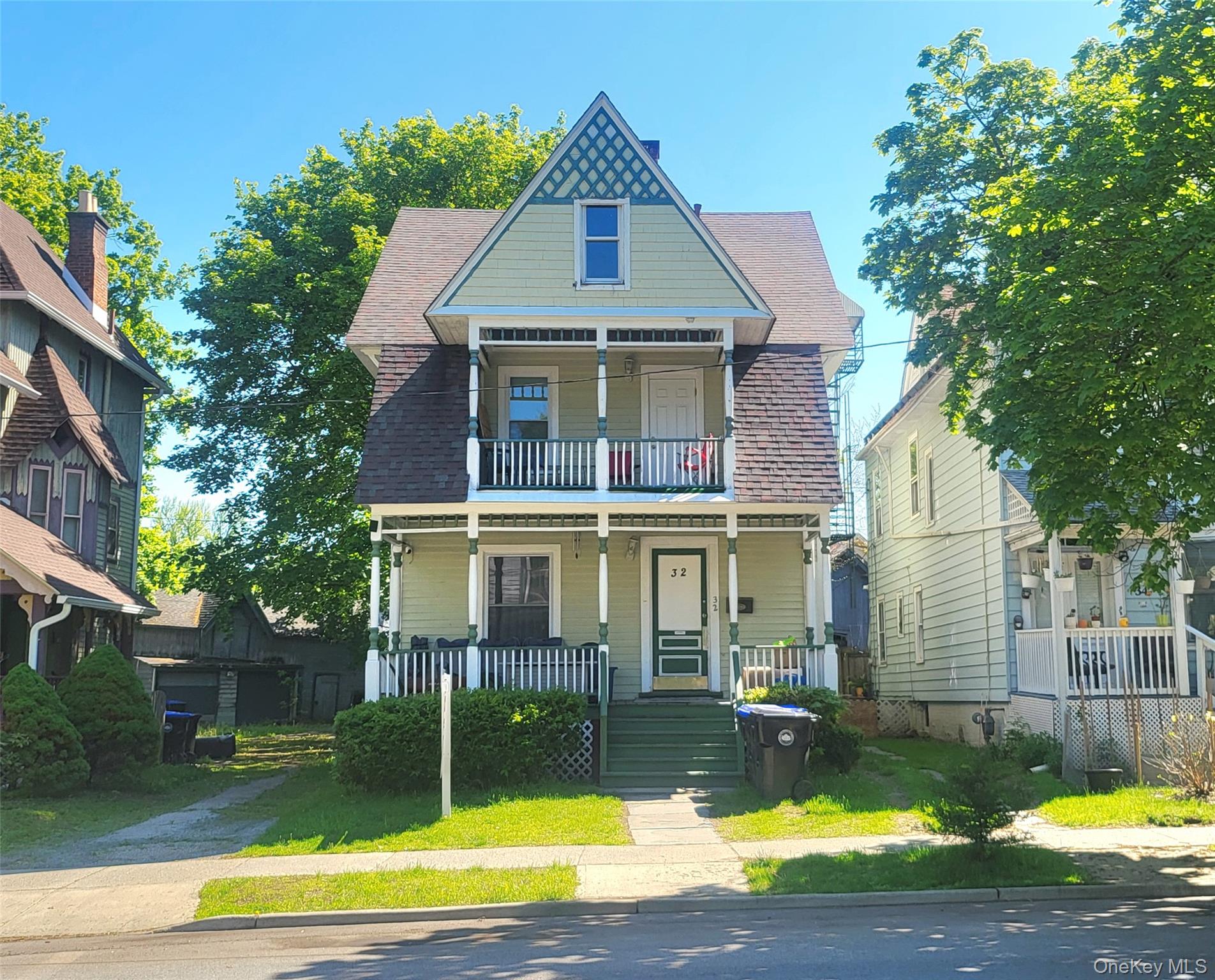 Colonial home.with covered porch, a balcony, and a shingled roof
