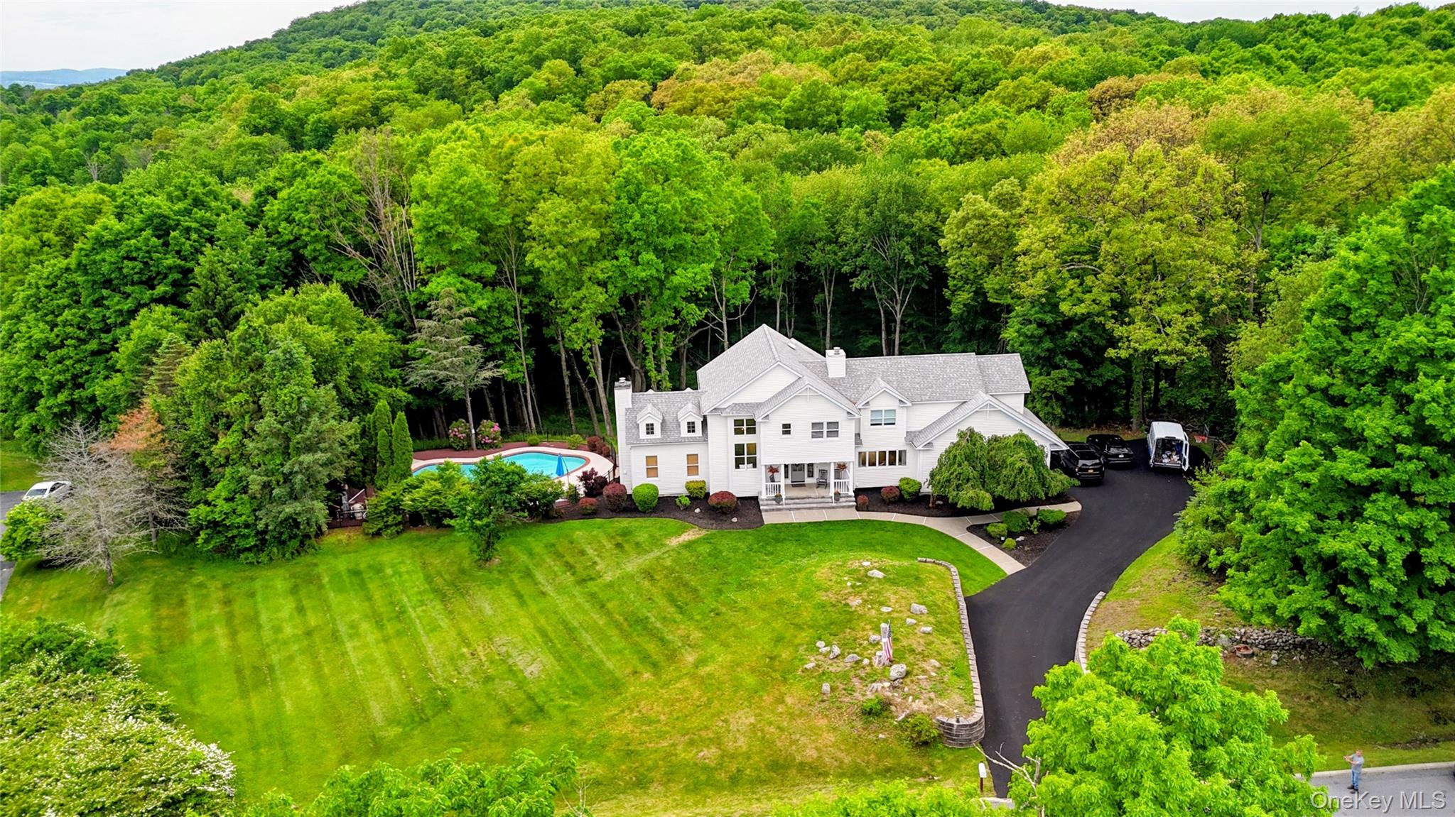 Expansive white multi-story residence with a multi-gabled roof and multiple chimneys