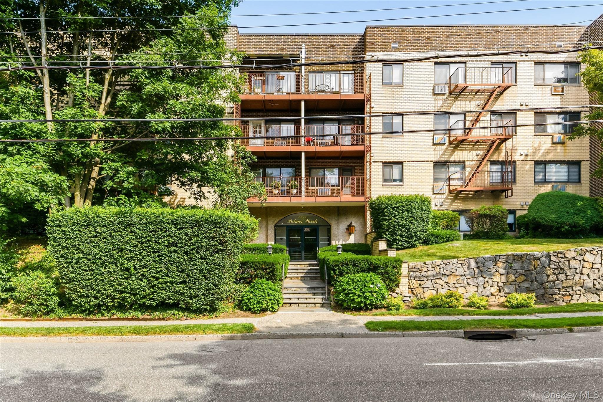 Multi-story residential building featuring a light-colored brick facade.