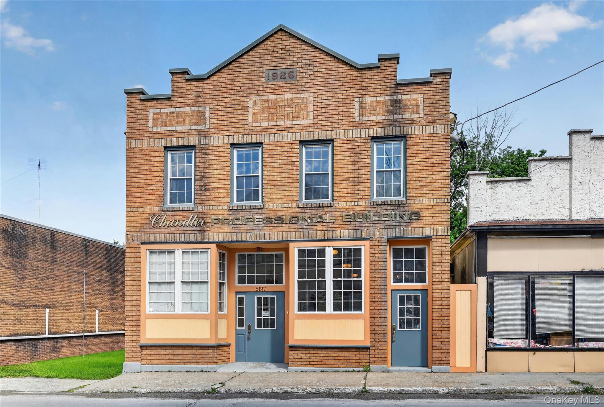 Three-story brick building facade featuring prominent \"1926\" and \"PROFESSIONAL BUILDING\" signage