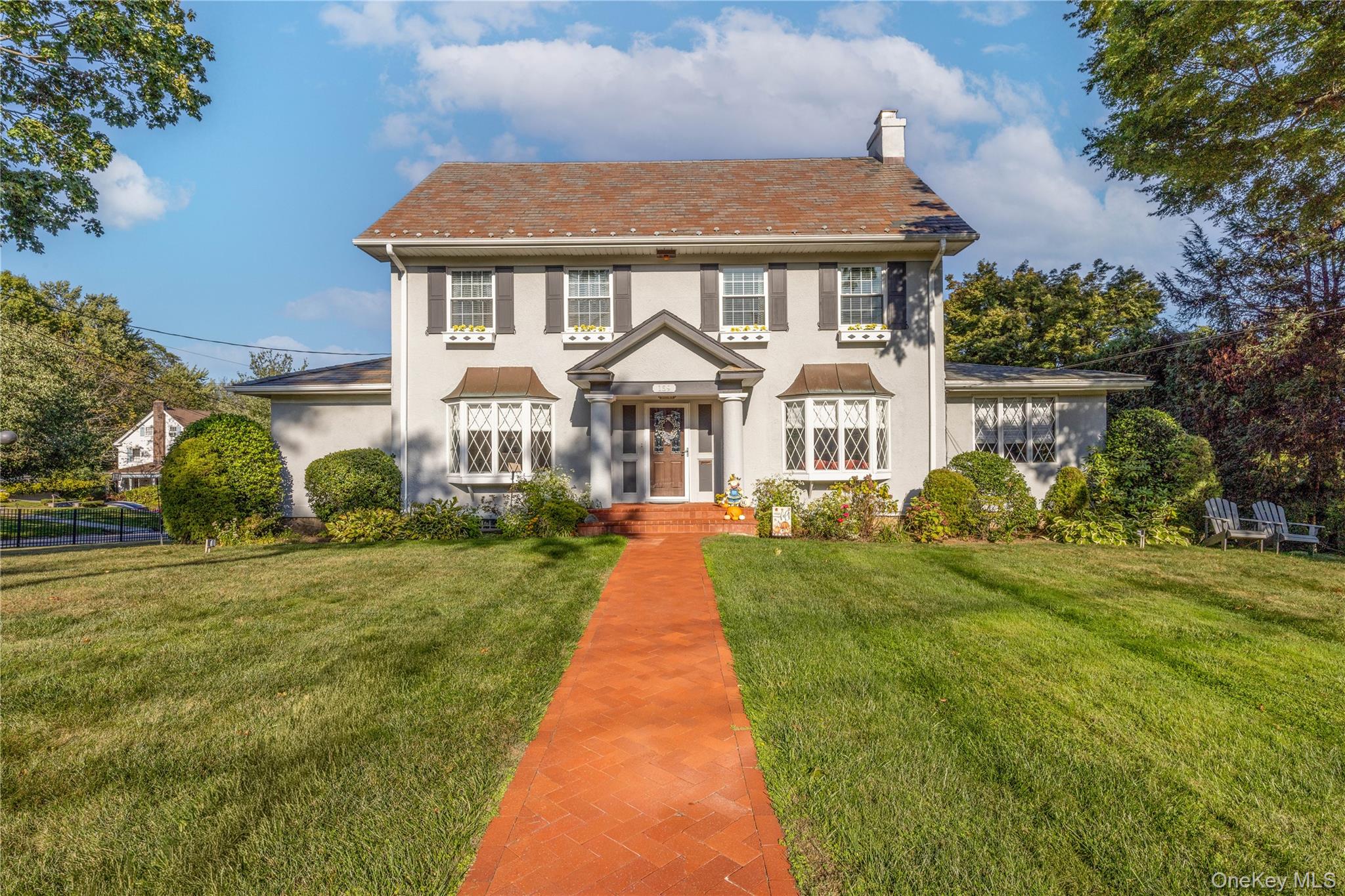 Classic center hall colonial on a large lot with a deep front lawn, herringbone brick walkway and timeless 2 story elegance