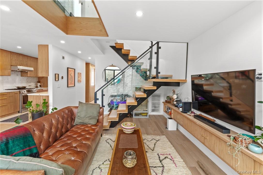 Welcome to your new home at 150 N Bedford Road. This stunning living area features an open-concept design with a chic floating staircase, high ceilings, and modern finishes, blending style and comfort seamlessly.