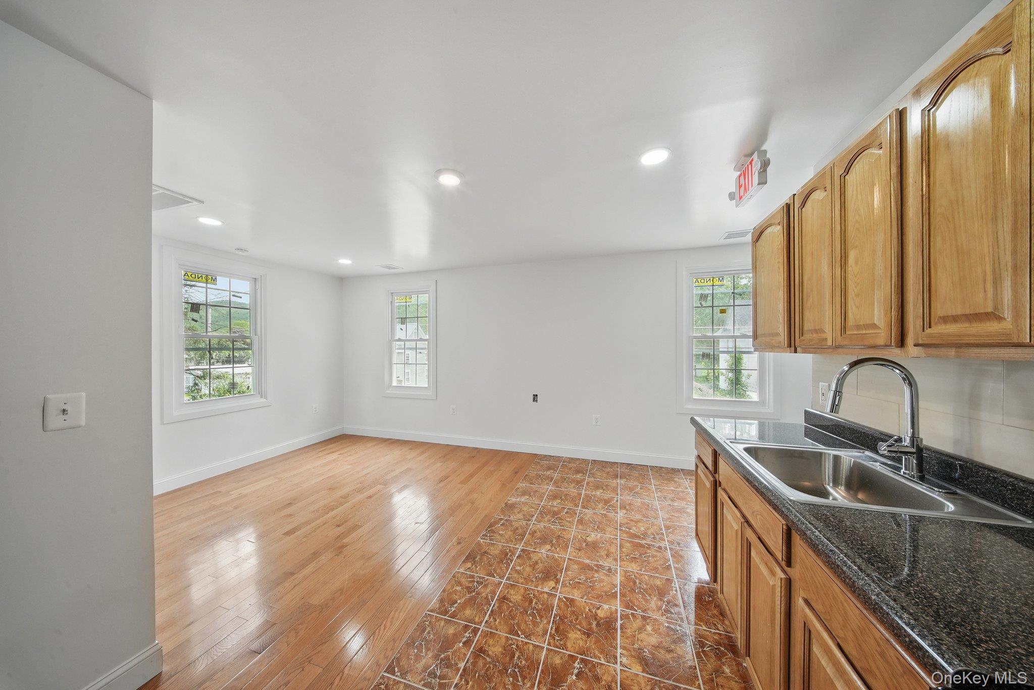 Open Kitchen/ Living room space with recessed lighting, natural light, wood floors, tiled kitchen