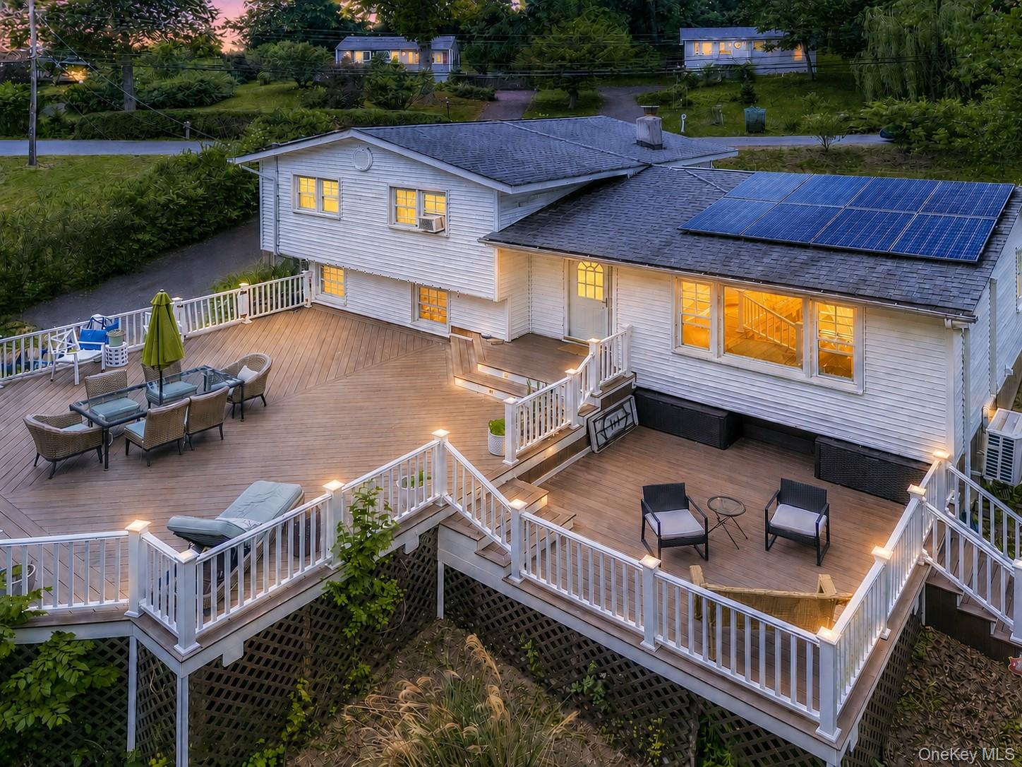 Multi-level outdoor deck featuring recessed lighting, white railings, and a large dining area