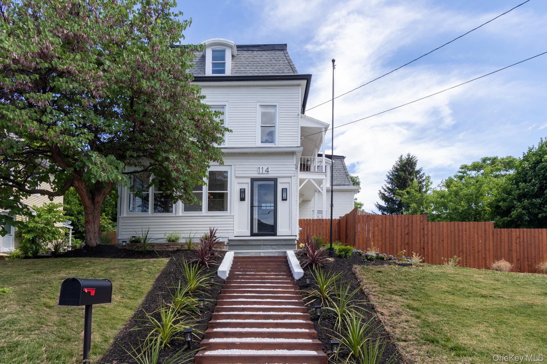 White clapboard exterior with a gambrel roof and dormer window