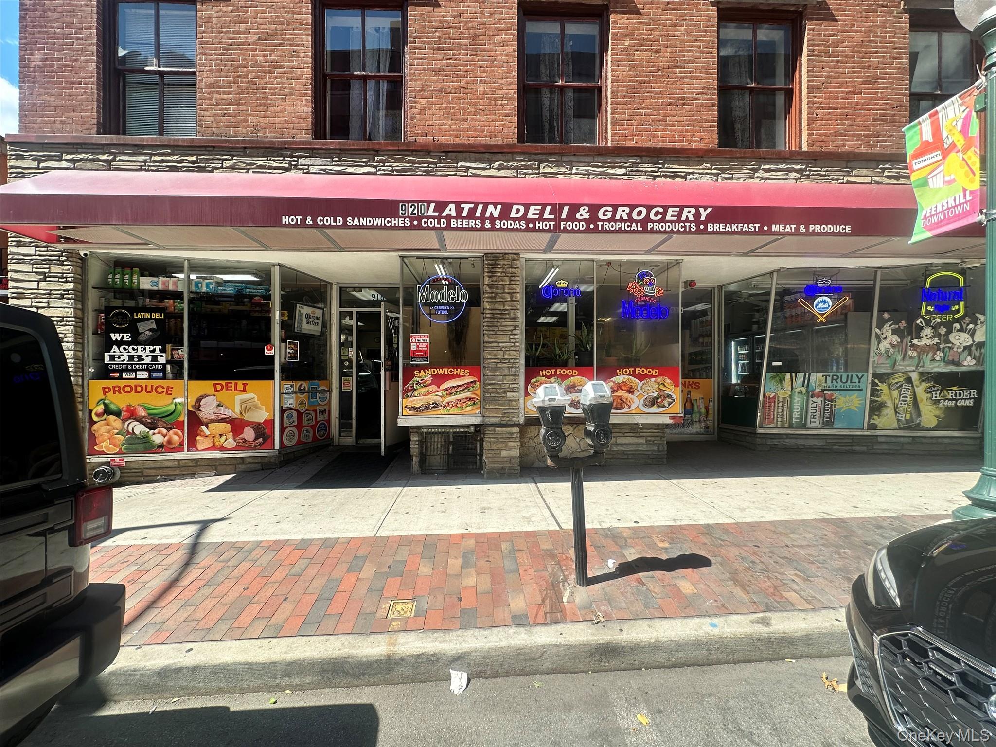 Commercial storefront with a red awning and prominent signage, featuring large display windows