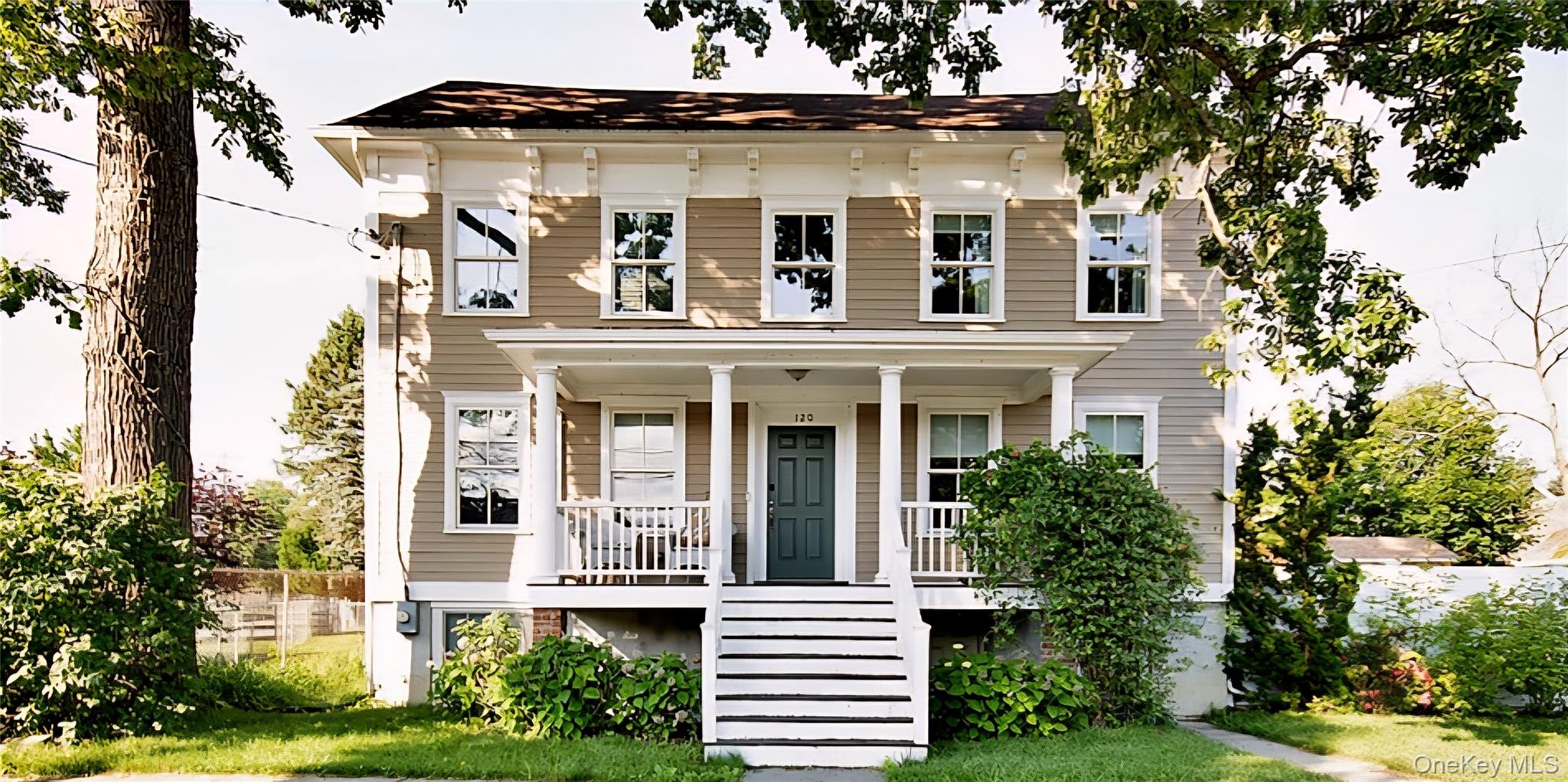 View of front facade featuring covered porch and stairway