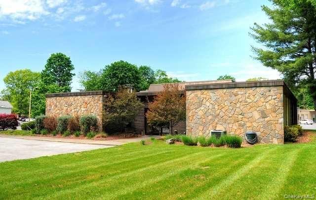 Beautiful stone facade with recessed entrance adorned with mature landscaping.