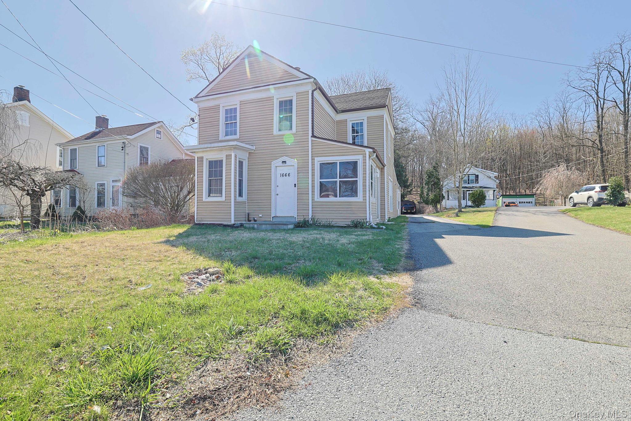 Traditional home with a front lawn and aphalt driveway