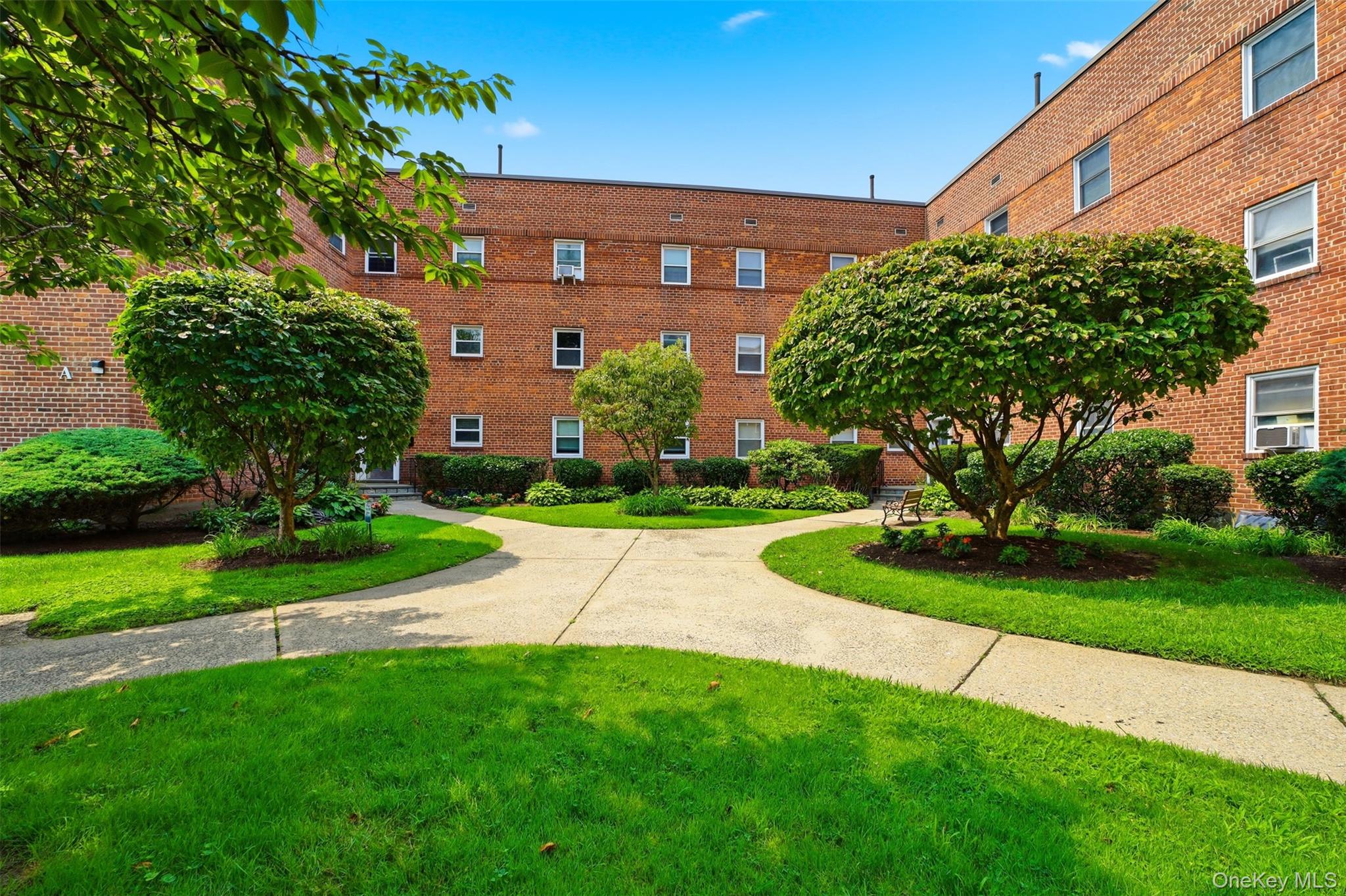 Well-maintained community courtyard with paved walkways and lush landscaping.